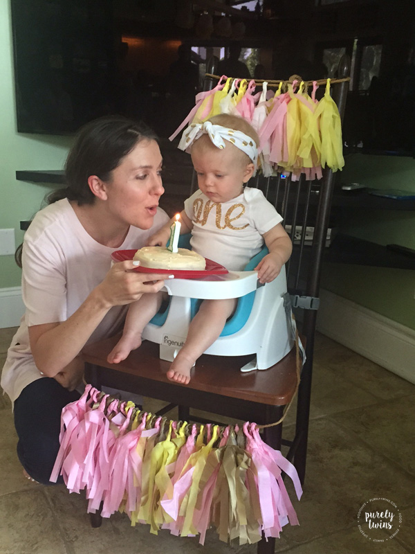 Mommy helping blow out candle on baby girl's first birthday cake. @purelytwins