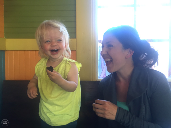 Toddler eating brownie and laughing.