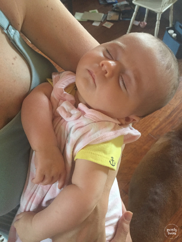 2 month old baby girl sleeping in moms arms