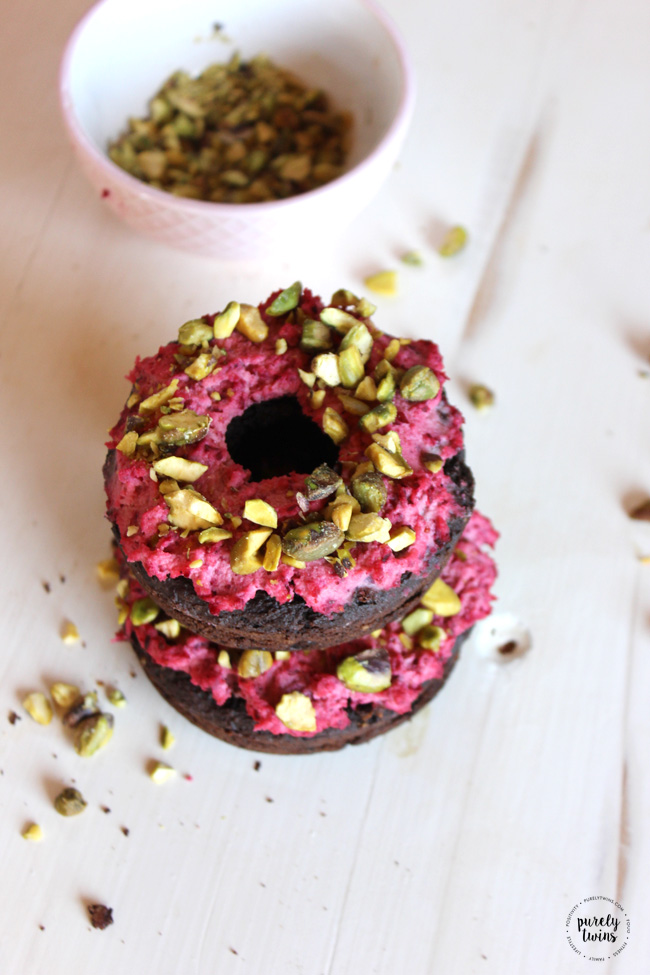 Super easy and fun gluten-free grain-free and egg-free Chocolate Protein Donuts with Cranberry Coconut frosting with crushed Pistachios. Delicious. Rich. And Moist. Chocolate Donuts with Cranberry Pistachio frosting recipe that is made in just 12 minutes. You won't believe what they are made out of!