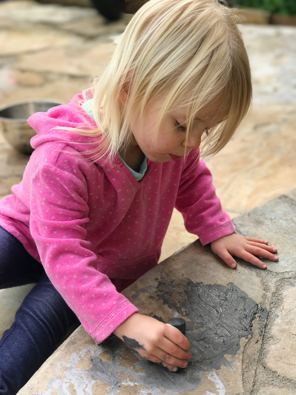 Toddler painting outside