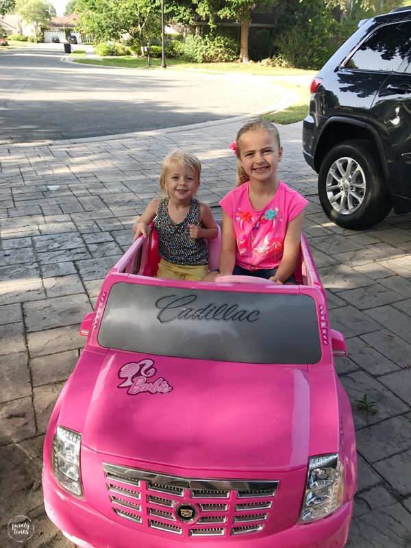 cousins playing in pink toy car